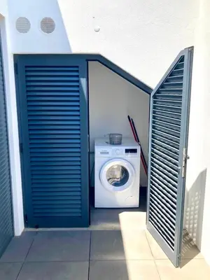 a washer and dryer in a building with a blue door at Villa Soligolf - Vilamoura, Algarve in Quarteira