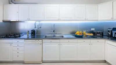 a kitchen with white cabinets and a sink at Lounge Garden Apartment in Vilamoura
