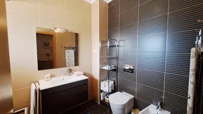 a bathroom with a sink and a toilet and a mirror at Jardins da Marina BQ in Albufeira