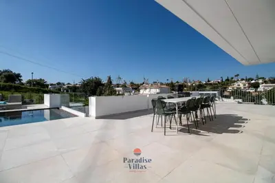 a dining room with a table and a mirror at Modern 4-Bedroom Villa with Infinity Pool in Albufeira