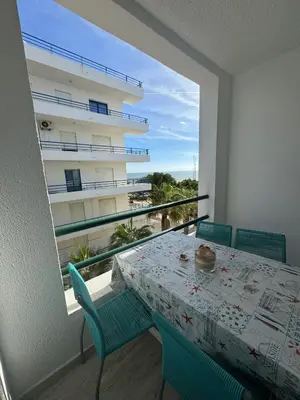a table and chairs on a balcony with a view of a building at Beach House in Quarteira