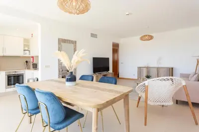 a dining room with a wooden table and blue chairs at Snazzy Varandas do Castelo One Bedroom Apartment sleeps 2 persons in Albufeira