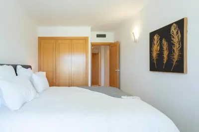 a bedroom with a white bed and a picture on the wall at Snazzy Varandas do Castelo One-Bedroom Apartment sleeps 2 person in Albufeira