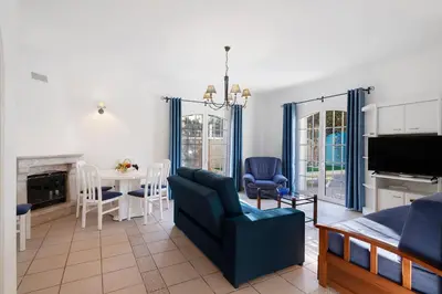 a living room with a couch and a dining room at Casa da Várzea in Albufeira