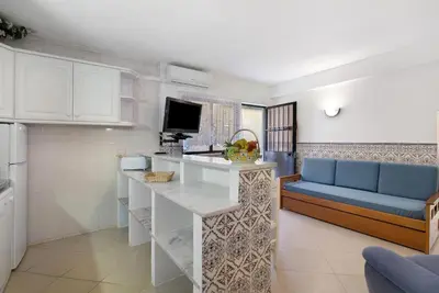 a kitchen and living room with a counter and a couch at Casa da Várzea in Albufeira