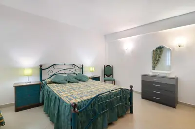 a bedroom with a bed and a dresser and a mirror at Casa da Várzea in Albufeira
