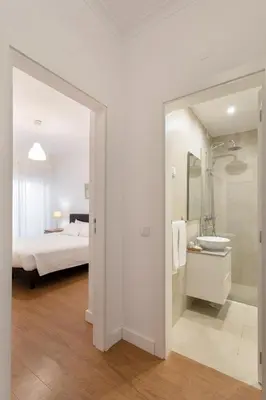 a bedroom with a bed and a bathroom with a sink at AL - Apartamentos Vista Mar in Quarteira
