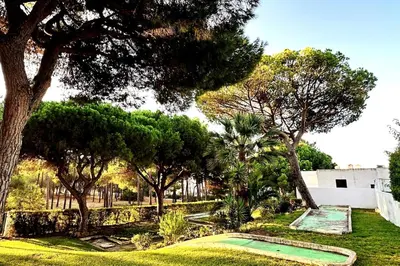 a group of lawn chairs in front of a house at Villa With BBQ and Pool in Vilamoura in Quarteira