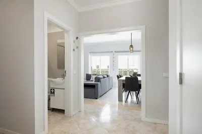 a white living room with a couch and a table at Mar e Golfe - Pool with golf view by HD in Vilamoura