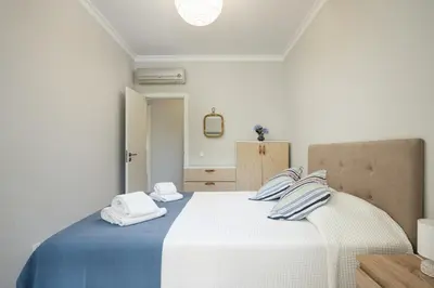 a bedroom with a bed with blue and white sheets at Mar e Golfe - Pool with golf view by HD in Vilamoura