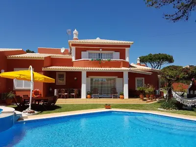 a house with a swimming pool in front of it at Vila Luz in Vilamoura