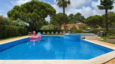 a swimming pool with a pink toy in the water at Vila Luz in Vilamoura