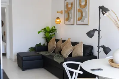 a living room with a black couch with pillows at Marina Praia - Marina view by HD in Vilamoura