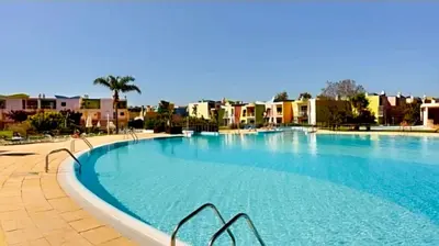 a large swimming pool with buildings in the background at Charming Orada 2-Bedroom Albufeira Duplex Apartment with Shared Pool sleeps 6 in Albufeira