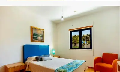 a bedroom with a bed and a window and a chair at Charming Orada 2-Bedroom Albufeira Duplex Apartment with Shared Pool sleeps 6 in Albufeira