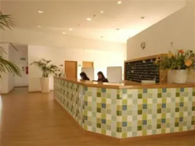 two people sitting at a counter in a lobby at Charming Orada 2-Bedroom Albufeira Duplex Apartment with Shared Pool sleeps 6 in Albufeira