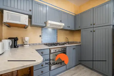 a bedroom with a bed with a home holidays sign on it at #352 Travessa do Mar Flats by Home Holidays in Albufeira