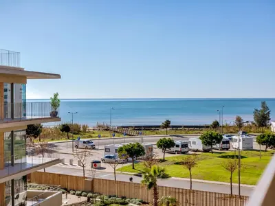 a view of a parking lot and the ocean at 2bdr Horizon Sand apartment in Quarteira in Quarteira