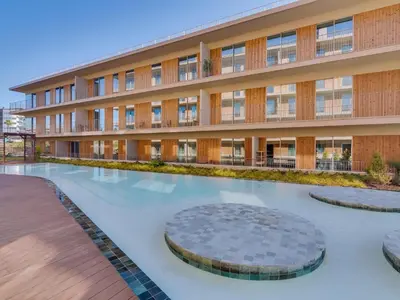 an external view of a building with a swimming pool at 2bdr Horizon Sand apartment in Quarteira in Quarteira