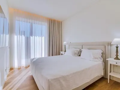 a bedroom with a white bed and a large window at 2bdr Horizon Sand apartment in Quarteira in Quarteira