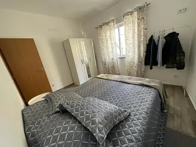 a bedroom with a bed with a pillow and a window at Casa do Outeiro - T2 Quarteira velha in Quarteira