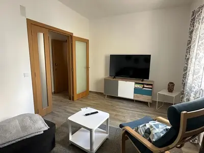 a living room with a couch and a tv at Casa do Outeiro - T2 Quarteira velha in Quarteira