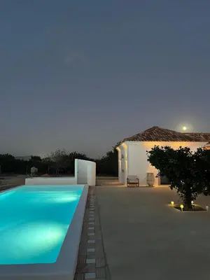 a swimming pool in front of a house at night at Casa Oliva do Sul in Almancil