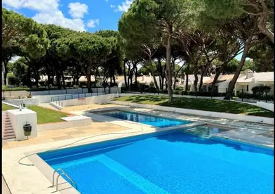 a large blue swimming pool with trees in the background at Studio Açoteias 410 in Albufeira