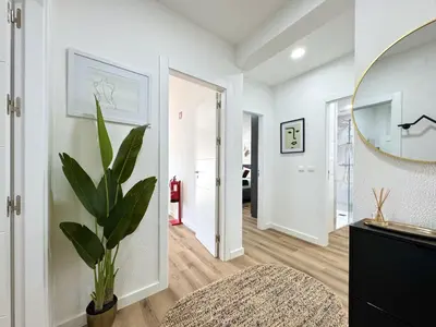 a hallway with a potted plant and a mirror at Albufeira Shine by Homing in Albufeira