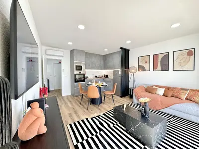 a living room with a bed and a dining room at Albufeira Shine by Homing in Albufeira