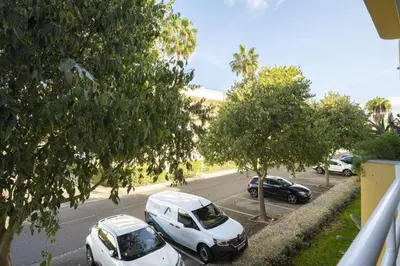 two white cars parked on a street with trees at Vilamoura fresh by Hd in Vilamoura