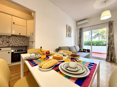 a kitchen and living room with a table with food on it at Vilamoura Downtown by Homing in Vilamoura