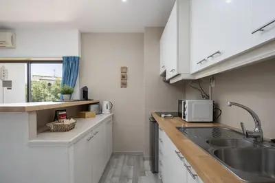 a kitchen and a living room with a table with a bottle of water at Albufeira Olympics 1BR Apartment with Pool & Balcony, by Hopstays in Albufeira
