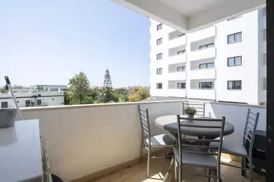 a living room with a couch and a tv at Albufeira Olympics 1BR Apartment with Pool & Balcony, by Hopstays in Albufeira