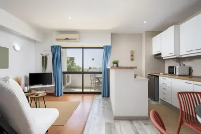 a balcony with a table and chairs and a building at Albufeira Olympics 1BR Apartment with Pool & Balcony, by Hopstays in Albufeira
