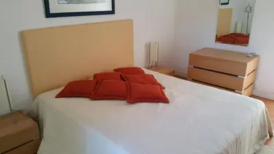 a bedroom with a bed with red pillows on it at Villapinheiros in Vilamoura