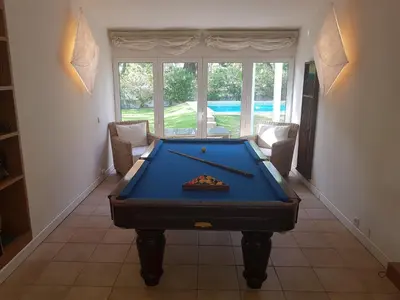 a pool table in a living room with a poolhibitionhibition at Villapinheiros in Vilamoura