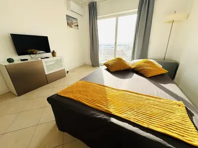 a bedroom with a bed with a yellow blanket on it at Blue Apartament in Albufeira