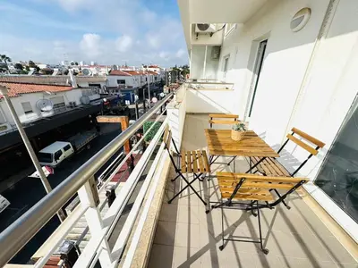a balcony with a wooden table and chairs on a building at Blue Apartament in Albufeira