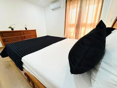 a bedroom with a bed with black pillows on it at Blue Apartament in Albufeira