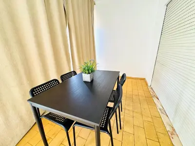 a black table with chairs and a potted plant on it at Apartamento gourmet com quintal in Albufeira