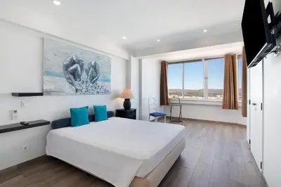 a bedroom with a large white bed with blue pillows at Delmar in Quarteira