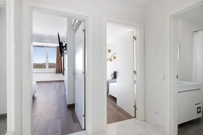 a white bathroom with a sink and a mirror at Delmar in Quarteira