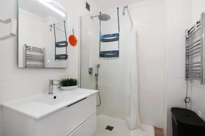 a white bathroom with a sink and a shower at Abertura Mar Zen in Quarteira