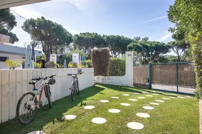 two bikes parked in a yard next to a fence at Bento Box Villa Family Hub Fitness in Vilamoura
