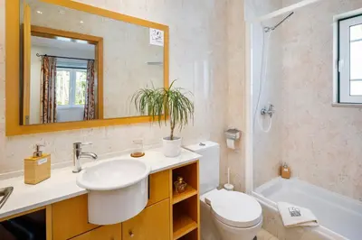 a bathroom with a sink and a toilet and a mirror at Pine Cliff Apartment by The Portuguese Butler in Olhos de Água