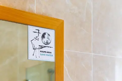 a sticker on a mirror in a bathroom at Pine Cliff Apartment by The Portuguese Butler in Olhos de Água