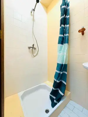 a shower with a blue shower curtain in a bathroom at Faro Family Apartment in Faro