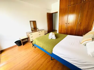 a bedroom with a bed with a dresser and a mirror at Faro Family Apartment in Faro