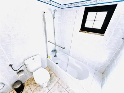 a white bathroom with a toilet and a shower at Studio com vista para Rua da Oura - Albufeira in Albufeira